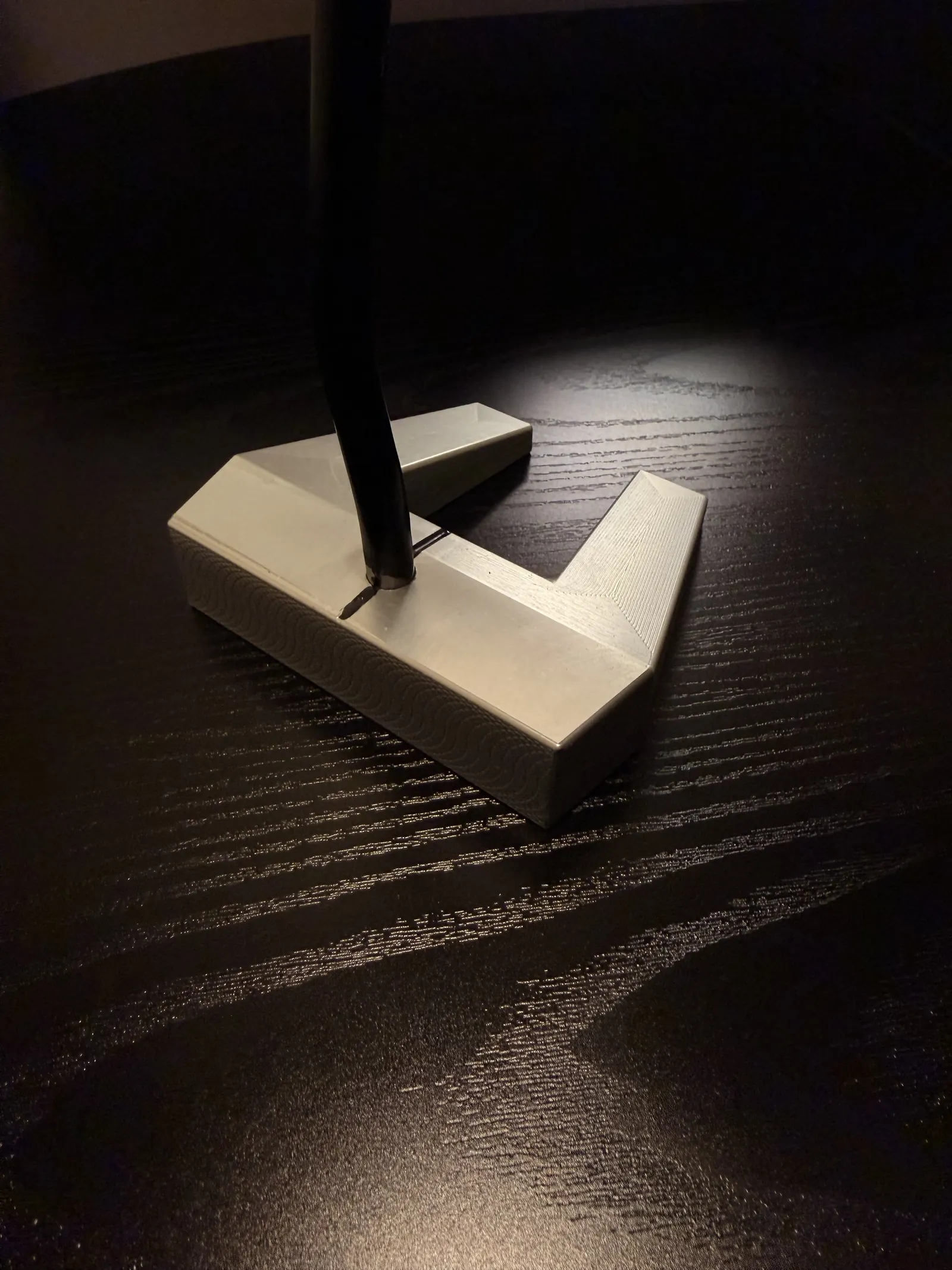 Close-up of the finished putter head showing milled surface pattern and shaft joint