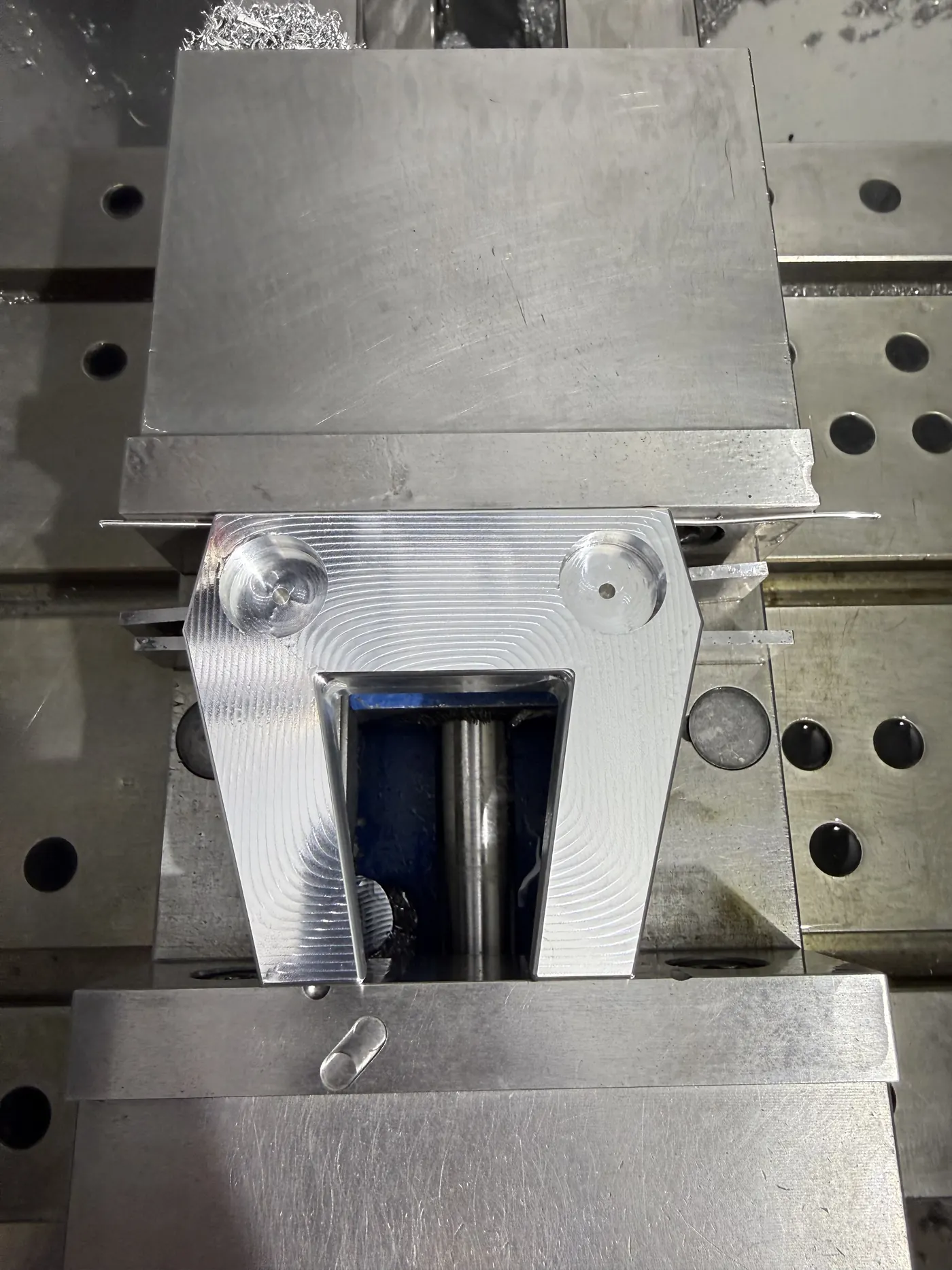CNC-fixtured view showing the weight pockets and underside geometry